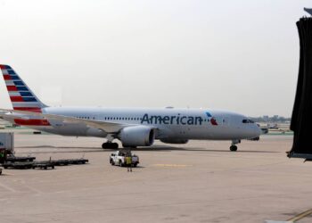 Woman refusing to get off phone on plane spits on passenger, slides down exit, feds say