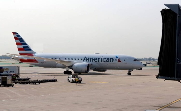 Woman refusing to get off phone on plane spits on passenger, slides down exit, feds say