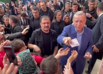 Erdogan hands cash to supporters at polling station